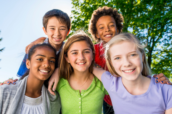 group of tweens smiling with various orthodontic needs 