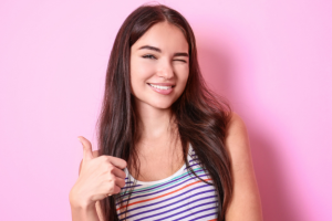 young woman with a beautiful smile shows perfect teeth after wearing retainer full time