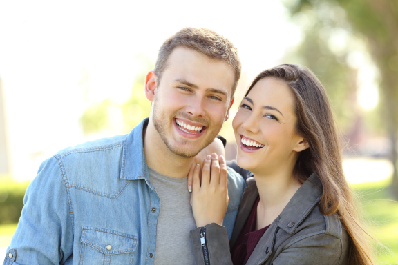 happy couple shows off beautiful smiles after Invisalign treatment 