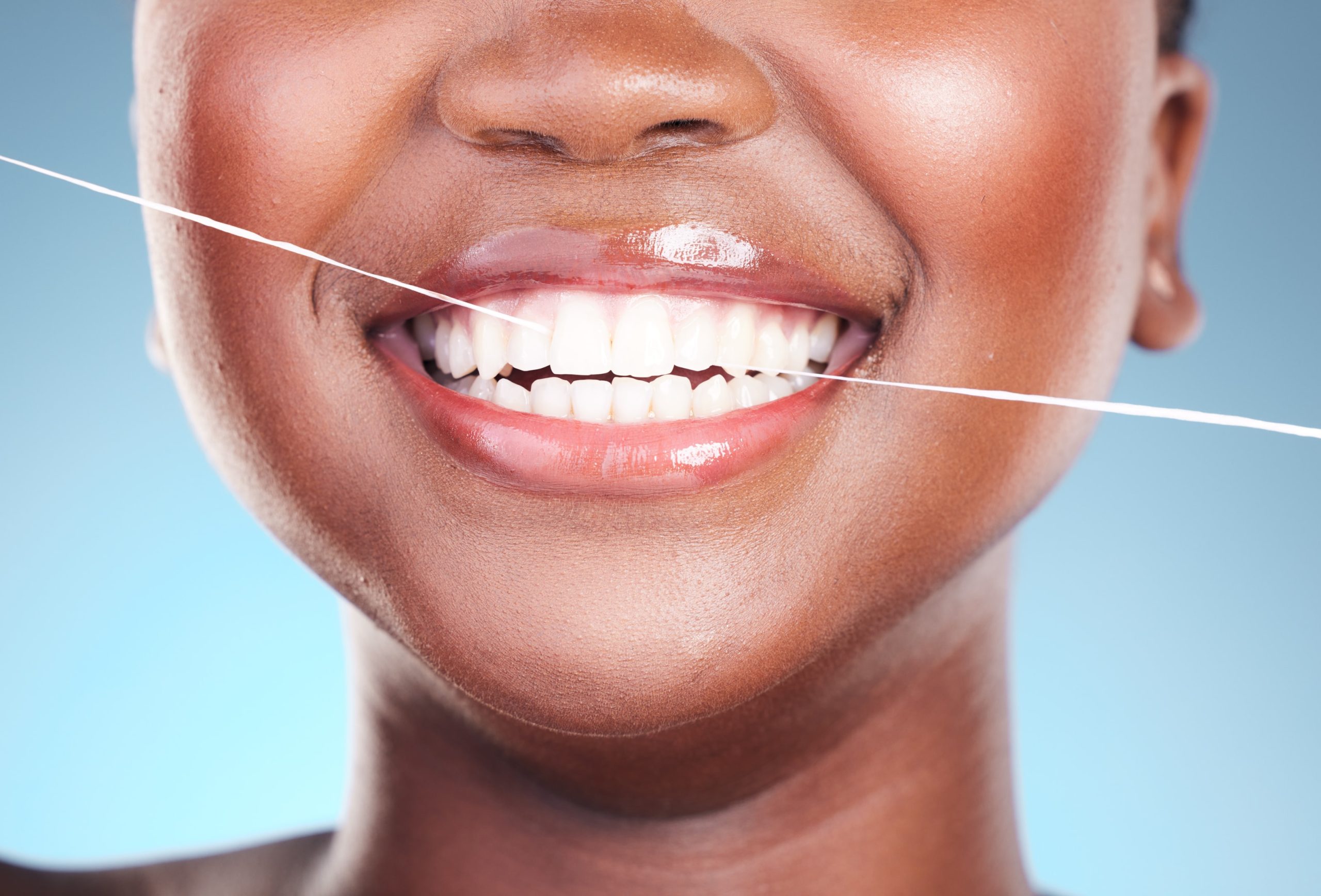 Woman flossing to make sure gums are healthy