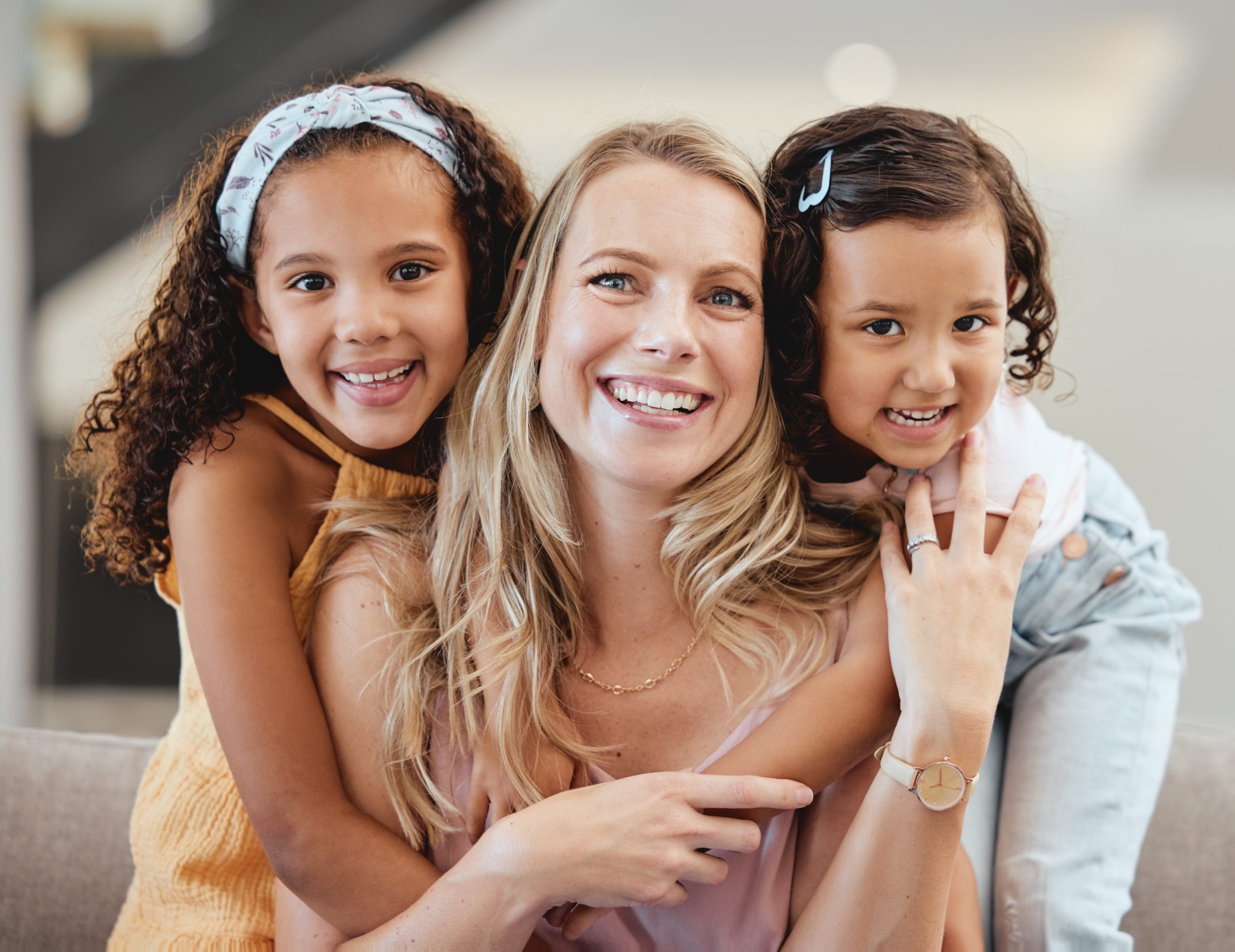 Mom smiling with her two daughters that have impacted teeth