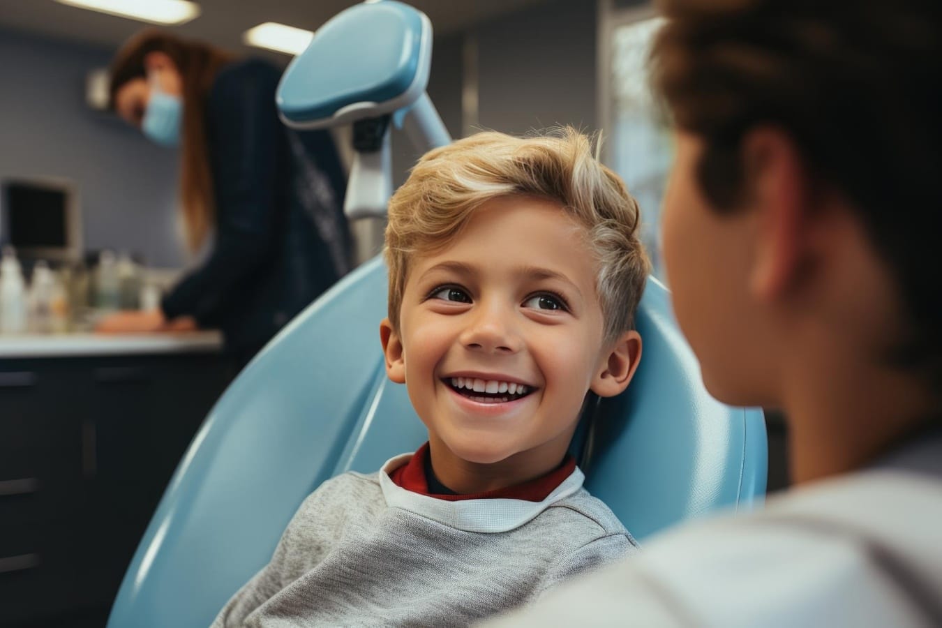 Kid smiling in patient chair ready to get a consultation