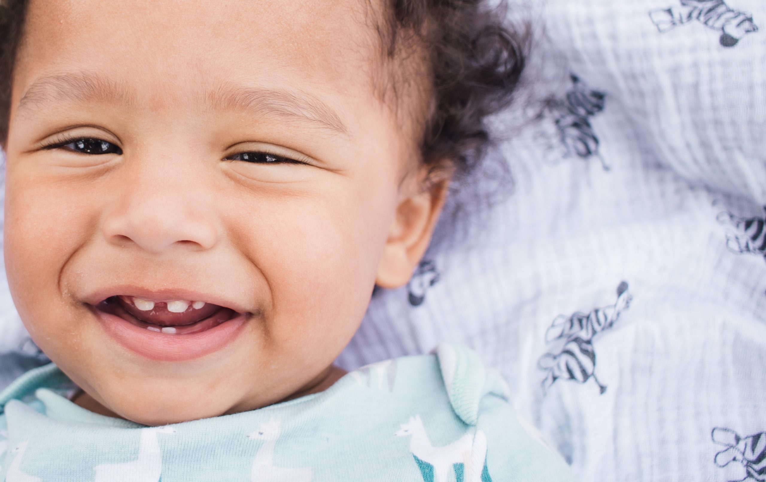 an infant with their first baby teeth growing in