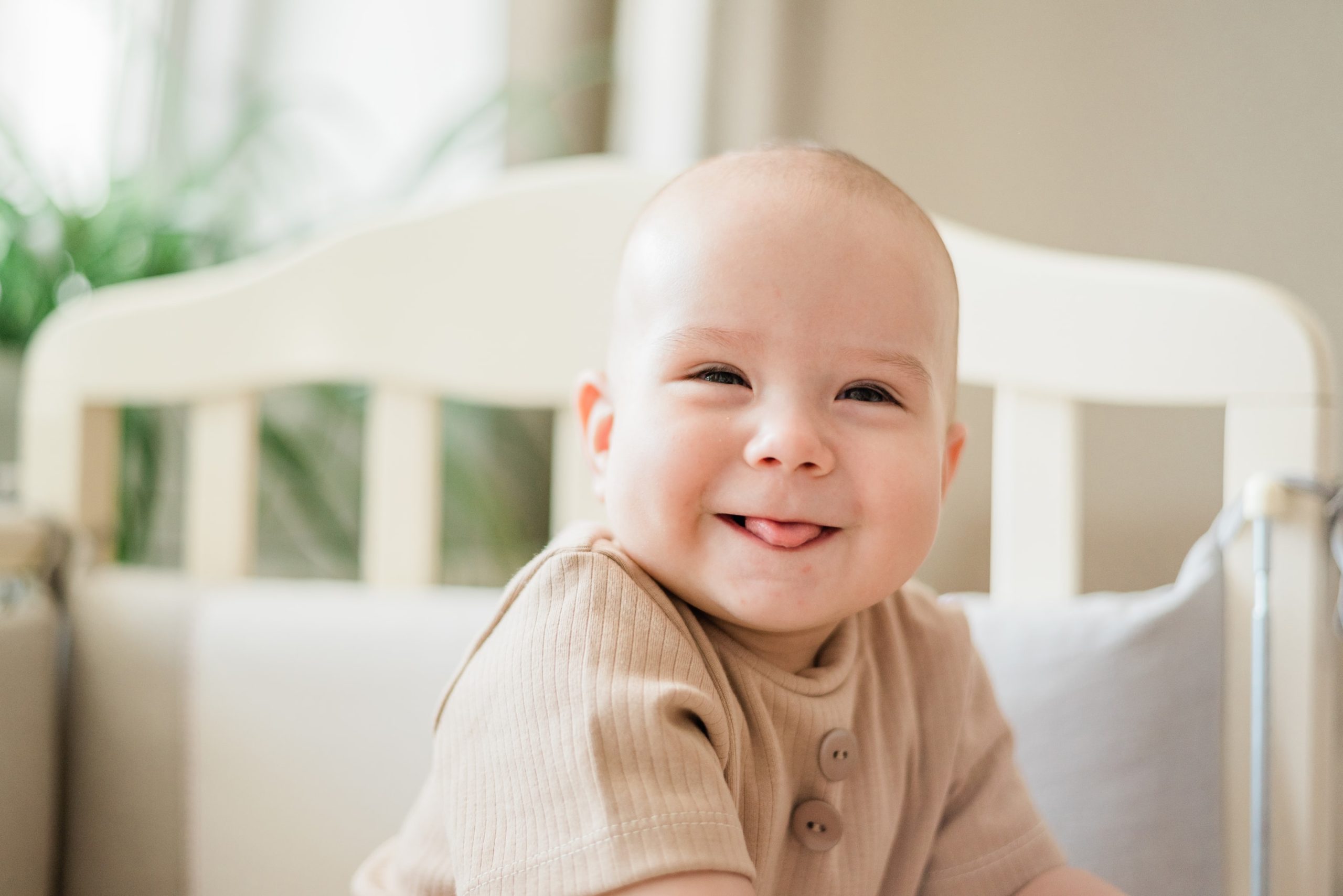 a smiling baby who's baby teeth are just now growing in