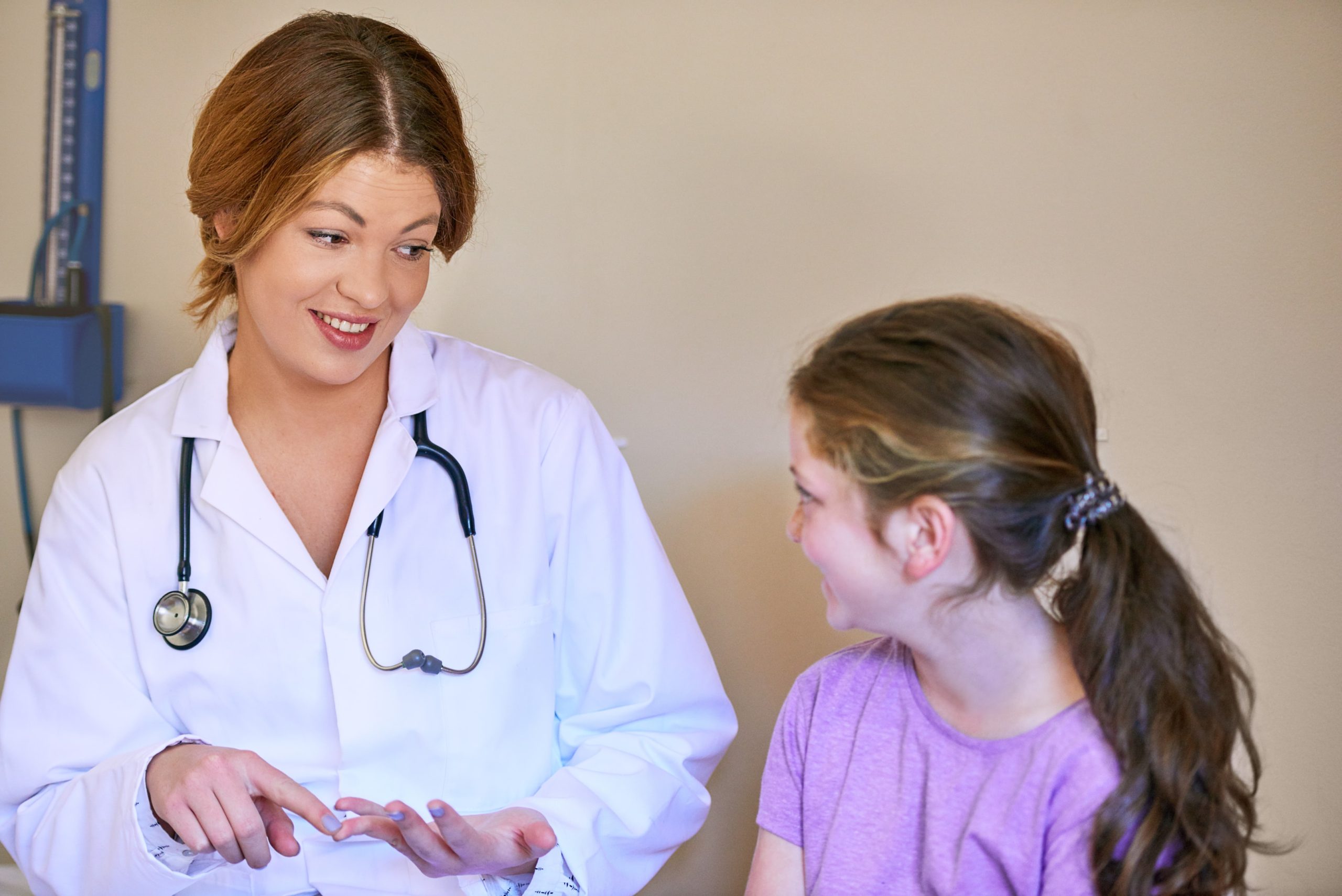 Doctor speaking to little girl about providing services