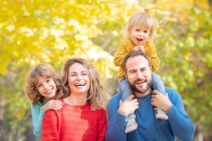 A smiling family of four who want a certified specialist with no hidden fees