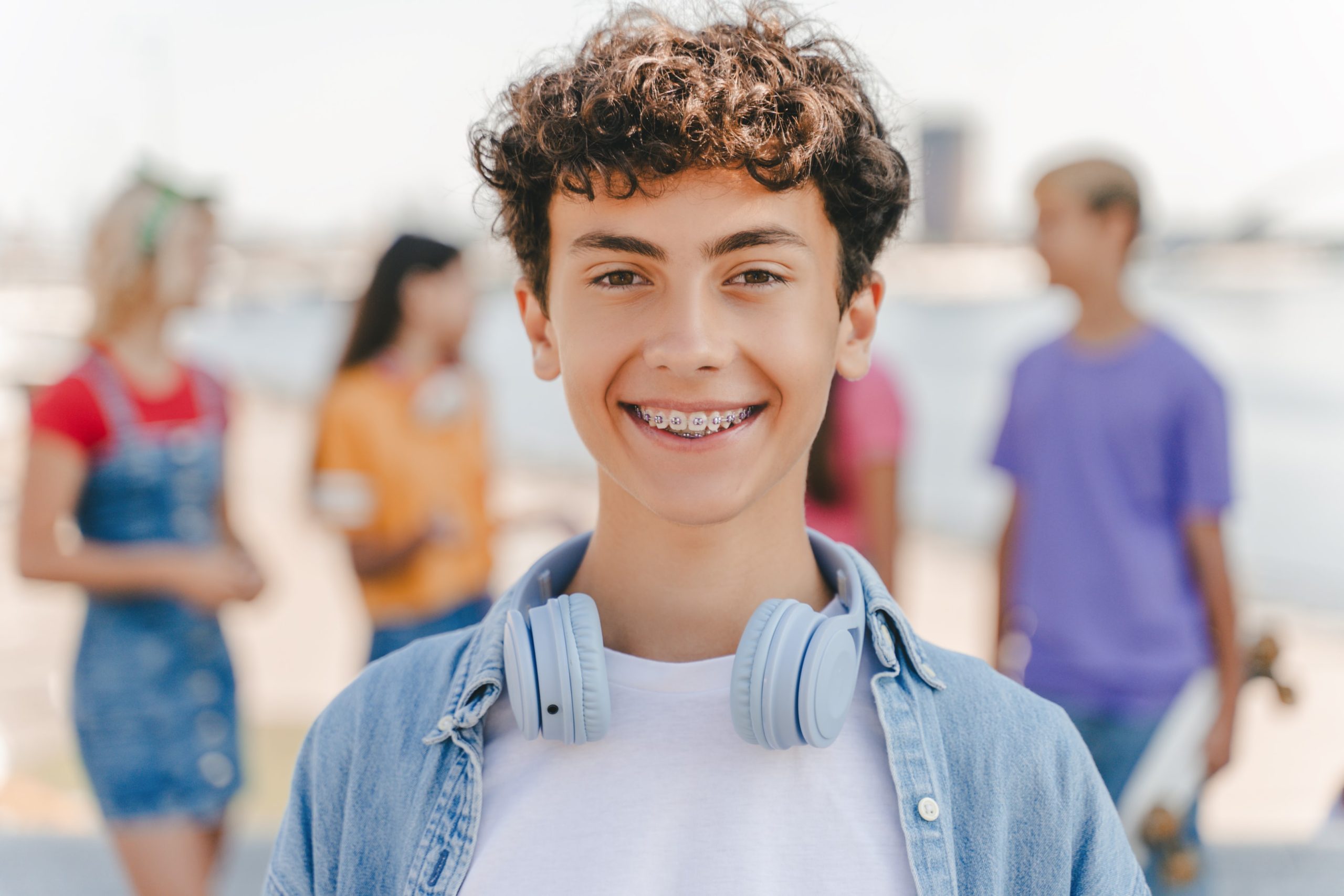 A boy smiling big showing off his new braces from Impact Orthodontics