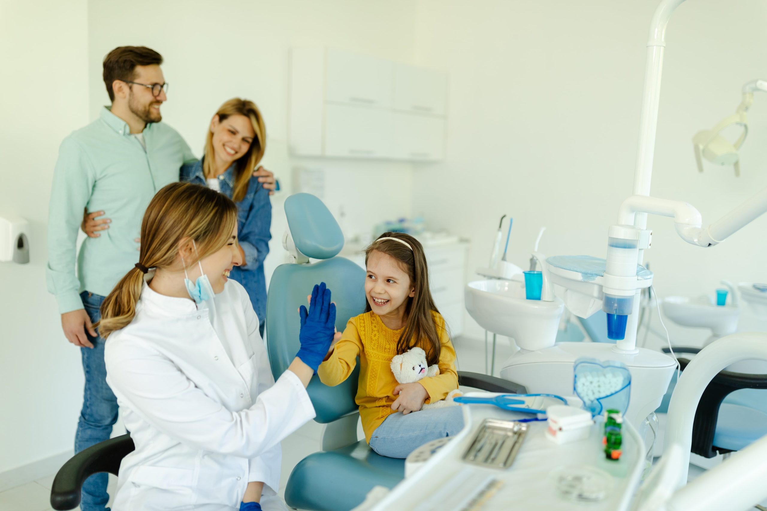 Female doctor is giving hi five to little girl after a successful dental examination for orthodontic treatment