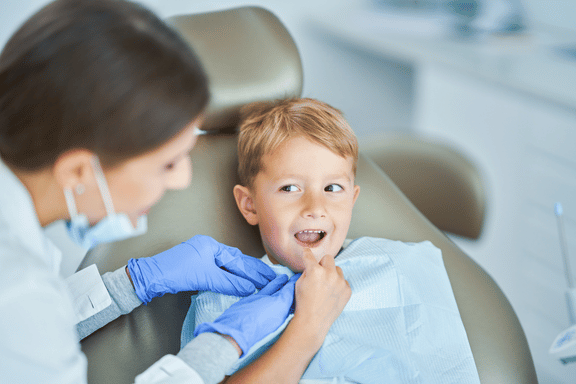 young boy with an open mouth having a dr assess his growth and need for early orthodontic treatment