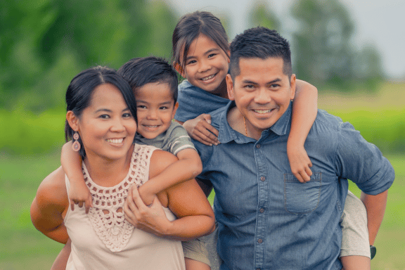 happy family with mother, father, daughter and son smiling