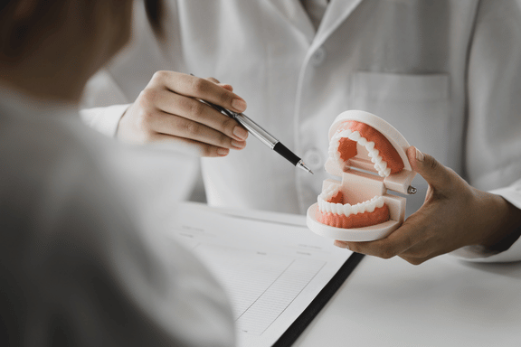 orthodontist explaining severe underbite to a patient using a dental model