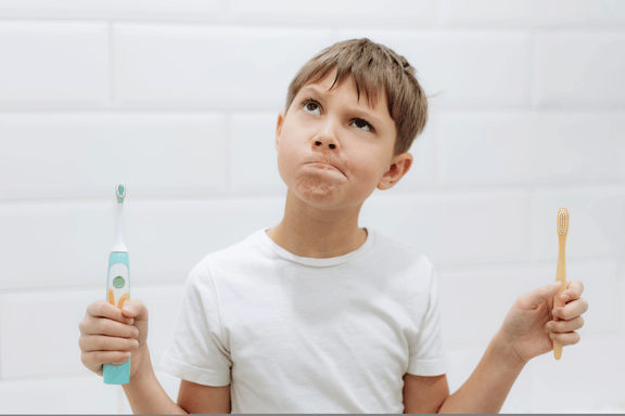 tween boy holding a tooth brush with an underdeveloped upper jaw 