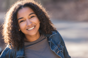 teen girl smiling and showing off her perfect smile from orthodontic treatment