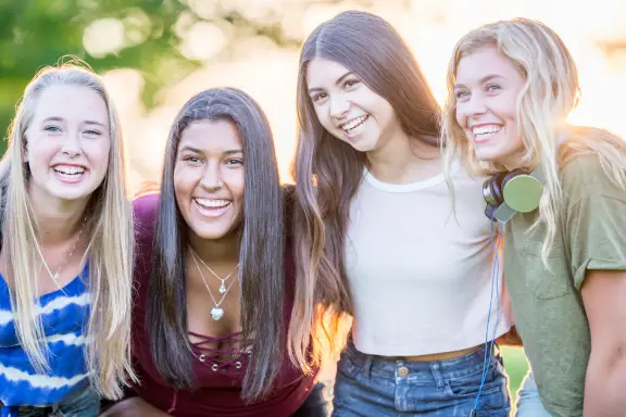 group of teens show off their beautiful straight teeth after orthodontic treatment