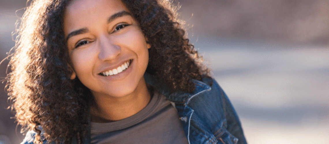 teen girl smiling and showing off her perfect smile from orthodontic treatment