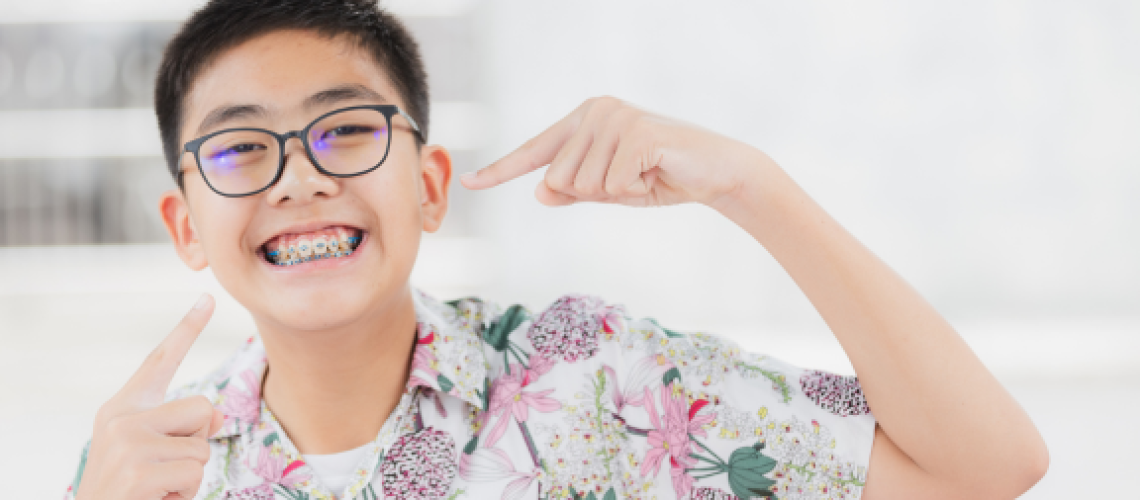 Smiling tween shows off his top and bottom teeth braces for his treatment plan