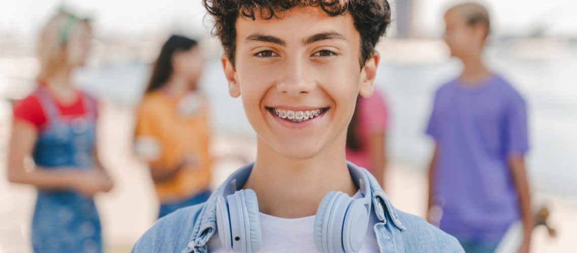 A boy smiling big showing off his new braces from Impact Orthodontics