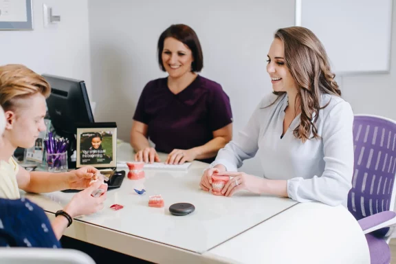 50df4ea5-1750-403f-975b-3269e66ed11b-scaled-1 a teen and his mother having an orthodontic consultation with Dr. Dena of Impact Orthodontics