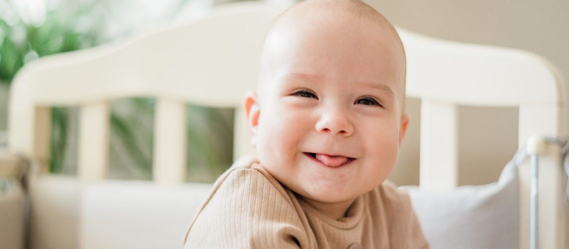 a smiling baby who's baby teeth are just now growing in